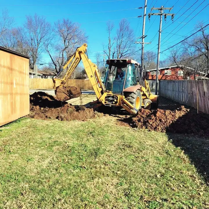 Messina's backhoe digging a trench on a residential lot, run by a licensed operator