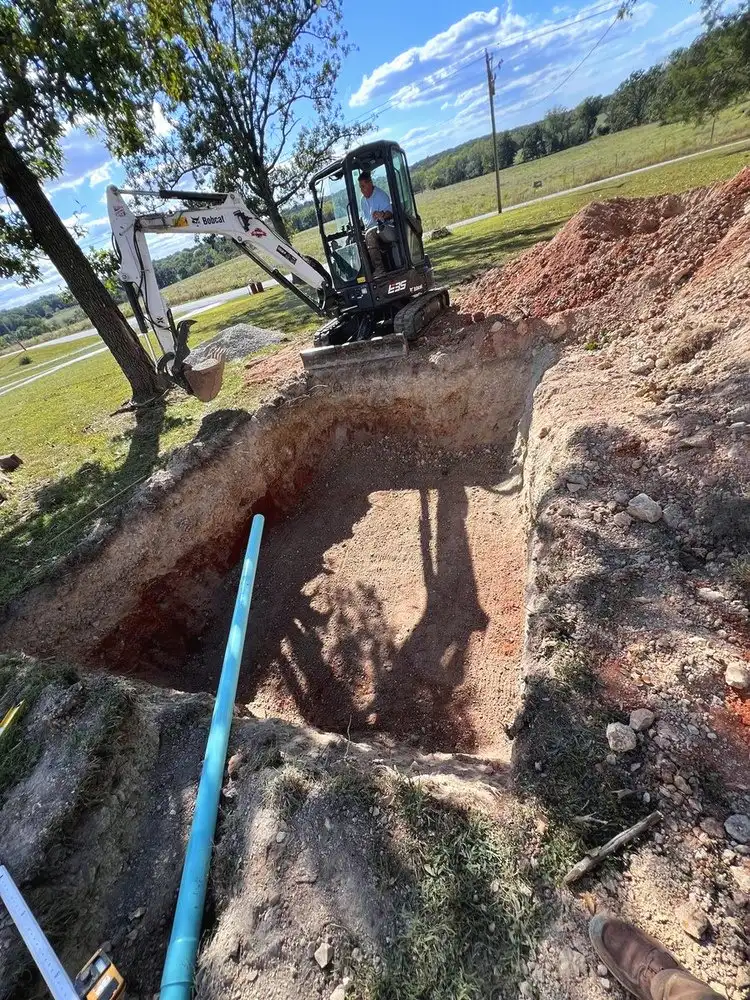 Mini excavator digging a trench in a yard