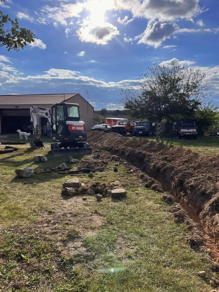 Open trench running from the yard to the house