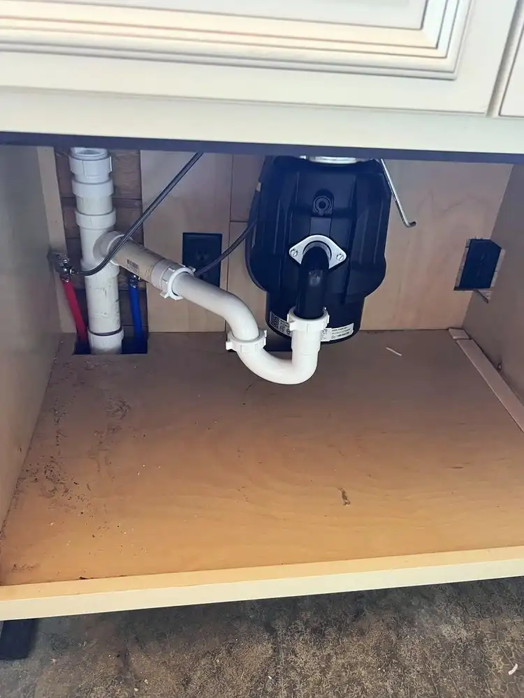 Drain and disposal plumbing under a kitchen sink