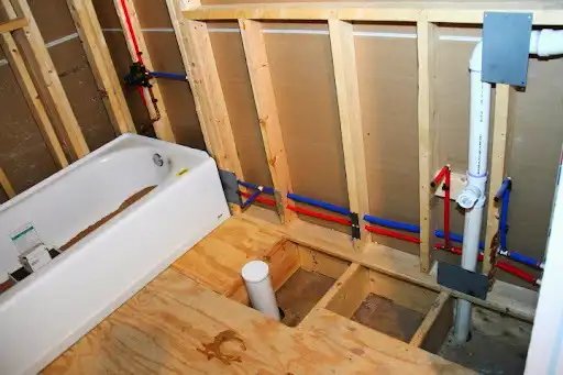 Bathroom plumbing roughed in with PEX and drain lines in the framing