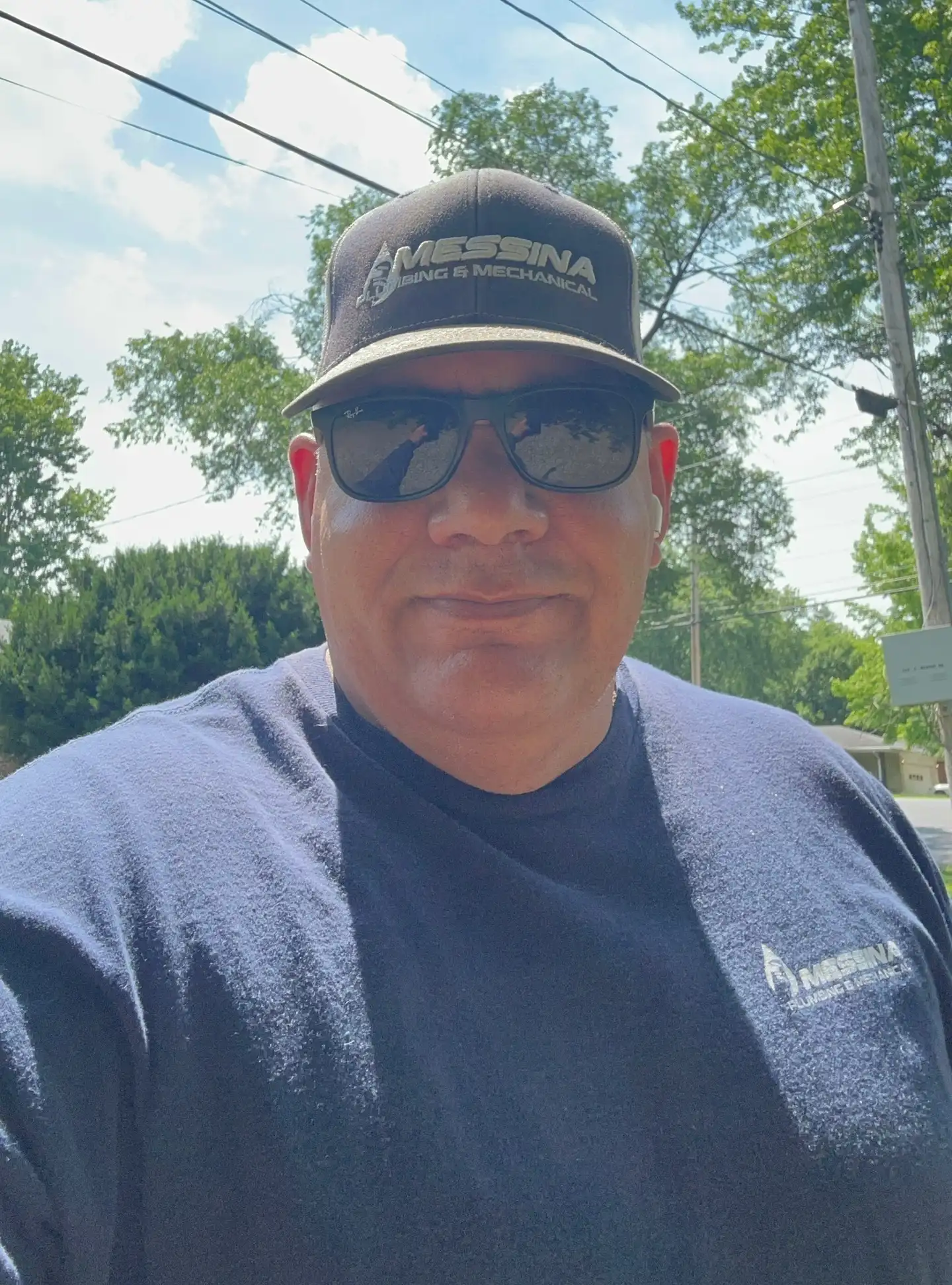 Joe Messina, master plumber and owner, in a Messina Plumbing & Mechanical cap and shirt